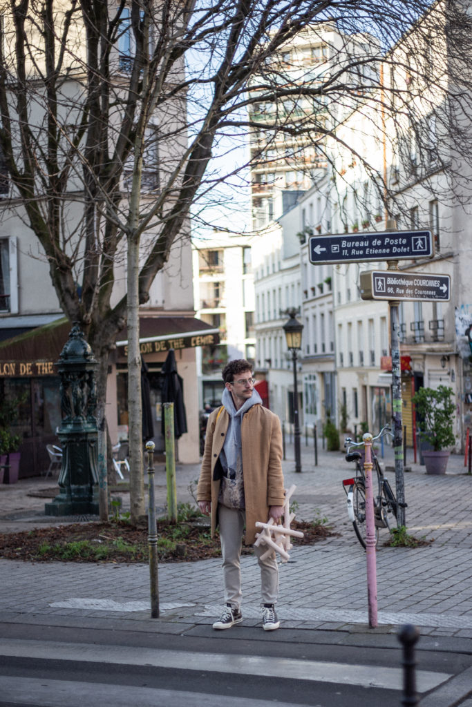 Mesut Ozturk à Ménilmontant (Paris) avec une sculpture de la série Sticks