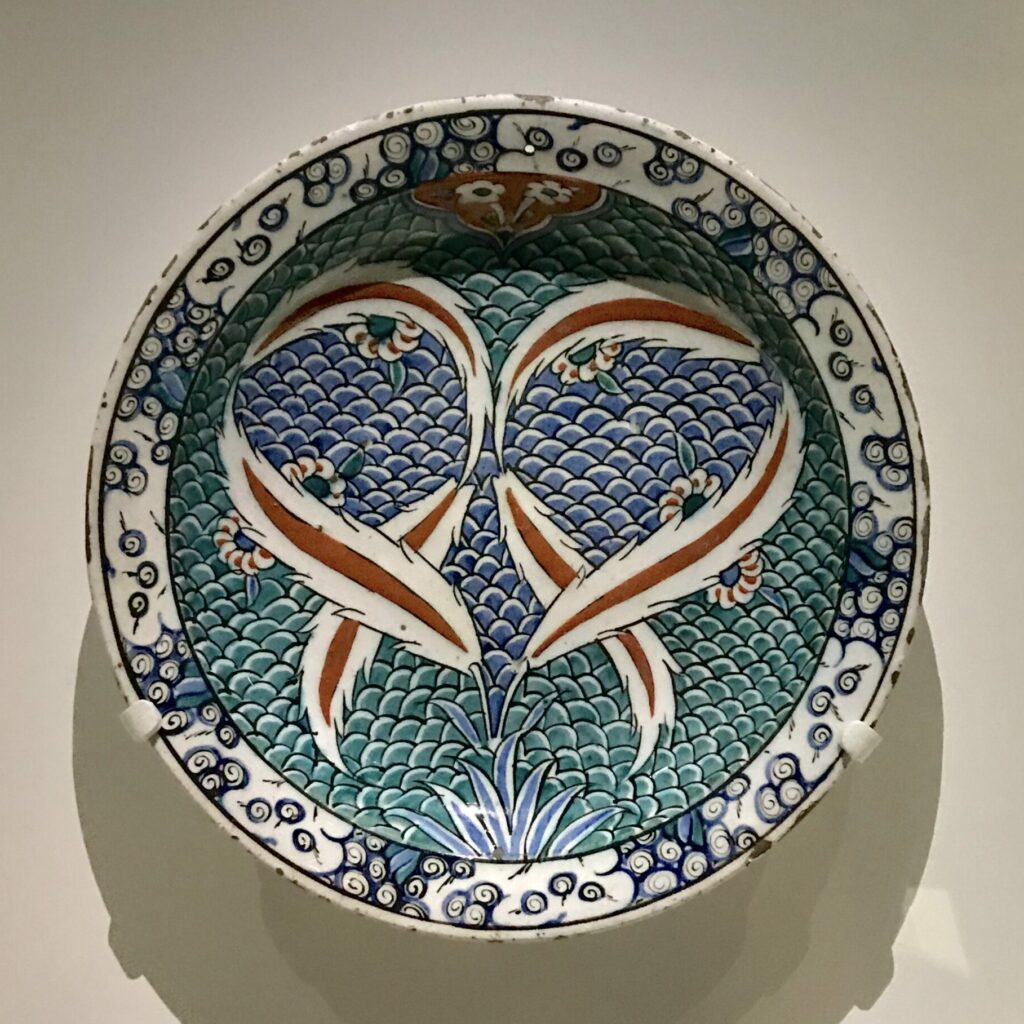 Plat en céramique d'Iznik (bleu, rouge, turquoise avec décor de plumes) de Turquie (exposition Cartier)