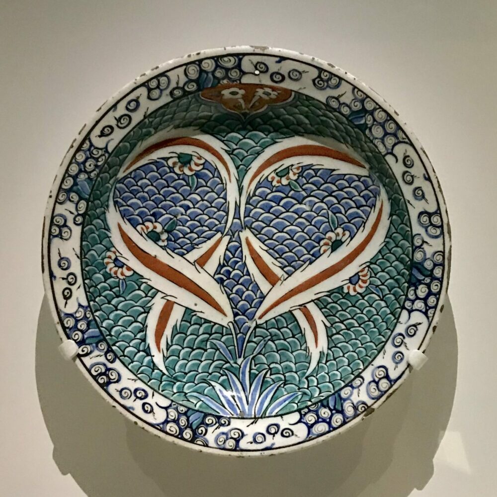 Plat en céramique d'Iznik (bleu, rouge, turquoise avec décor de plumes) de Turquie (exposition Cartier)