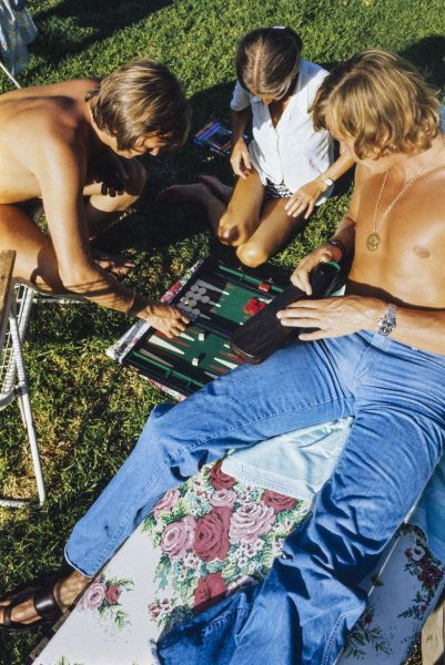 James Hunt joue au backgammon avec ses amis sur l'herbe.